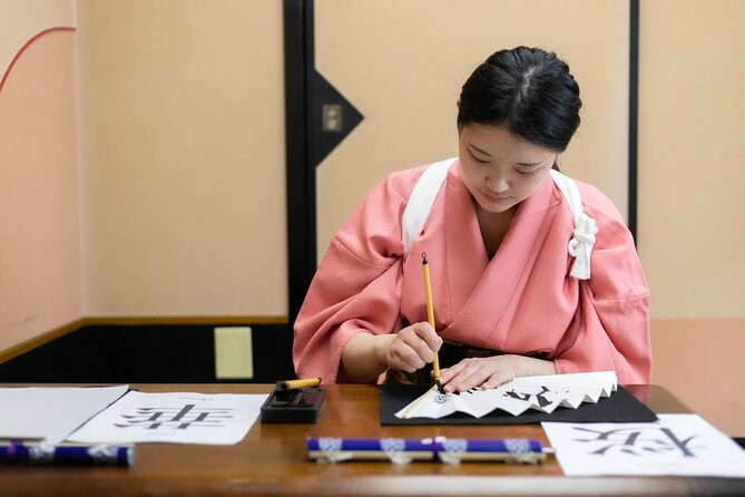 Learning Zen of Japanese Calligraphy in kimono near Osaka Castle - Writing your name in kanji on a wooden tag